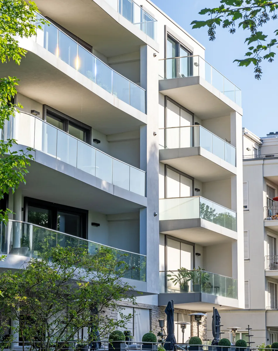 Immeuble moderne avec balcons vitrés et arbres
